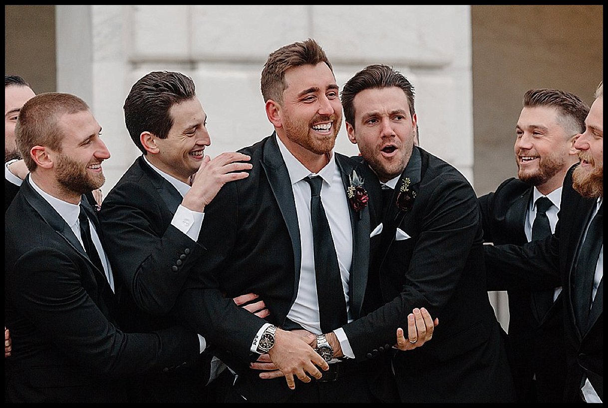 A wild groomsman party during wedding photos outside of the DIA during this glamorous winter wedding in Downtown Detroit.
