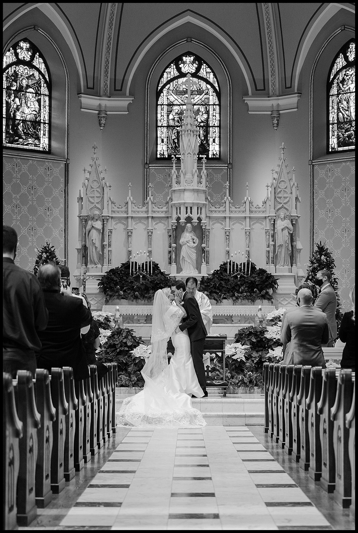  Bride and groom first kiss at catholic wedding ceremony in detroit, michigan.  