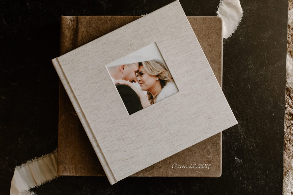 Two wedding albums stacked on top of each other with an image of a couple on the cover of the top album. 