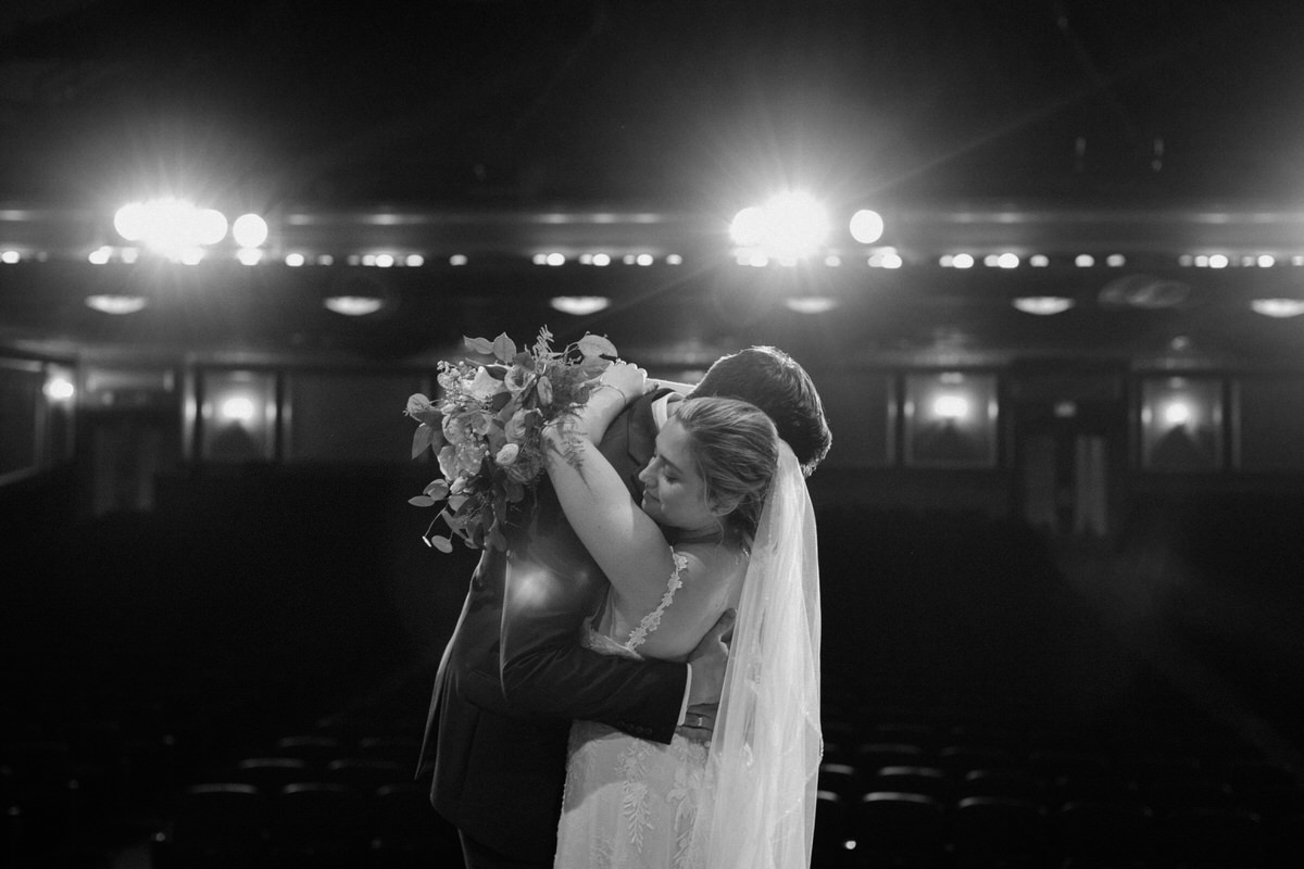 black and white wedding photo showing bride and groom slow dancing alone