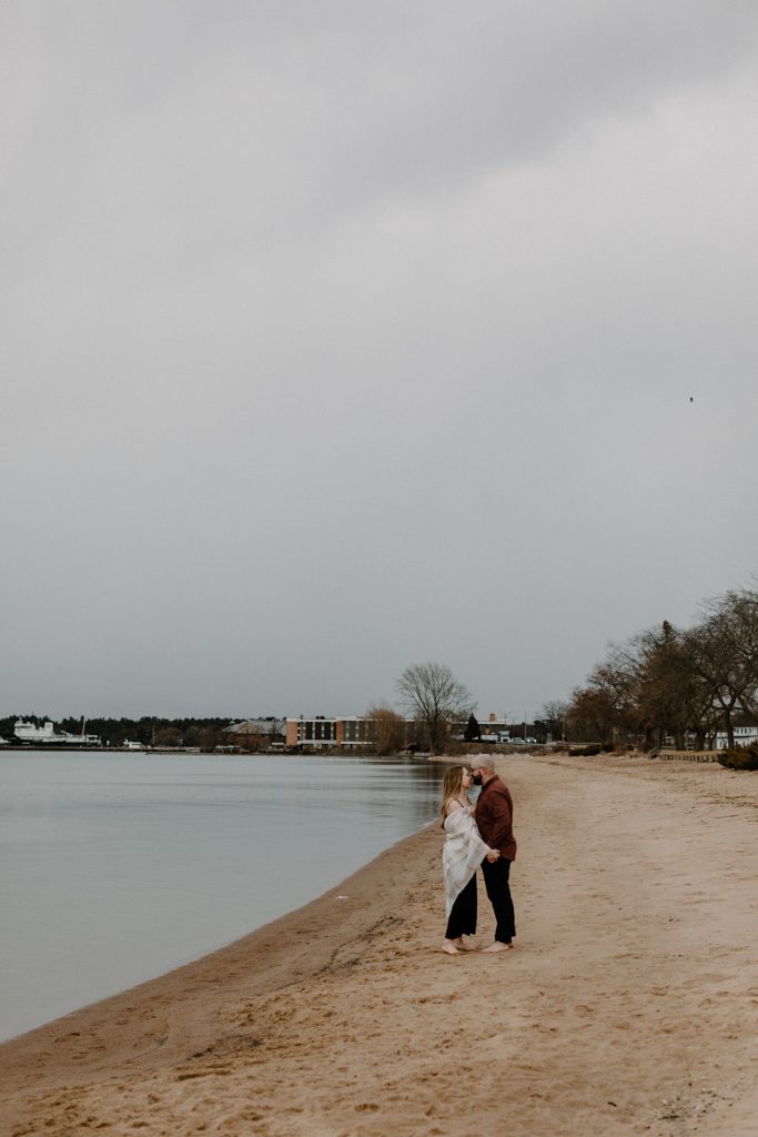 couple about to kiss as they stand on a beach 