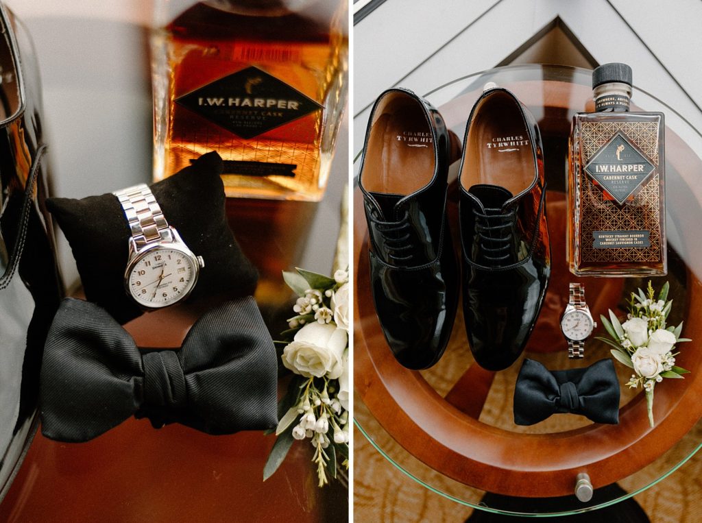 grooms shoes, jewelry, perfume, bowtie, and boutonniere laid out on a table  