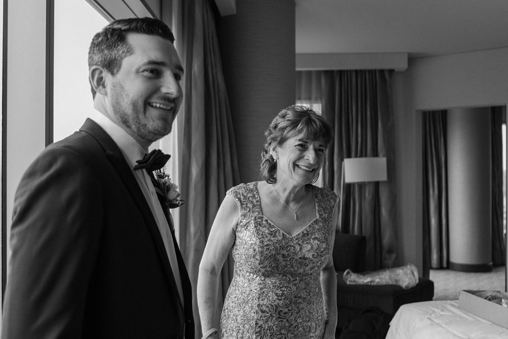 mother and groom standing next to each other smiling 