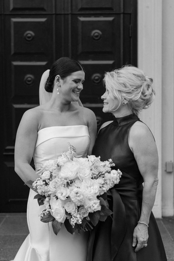 mother and bride looking at each other smiling 