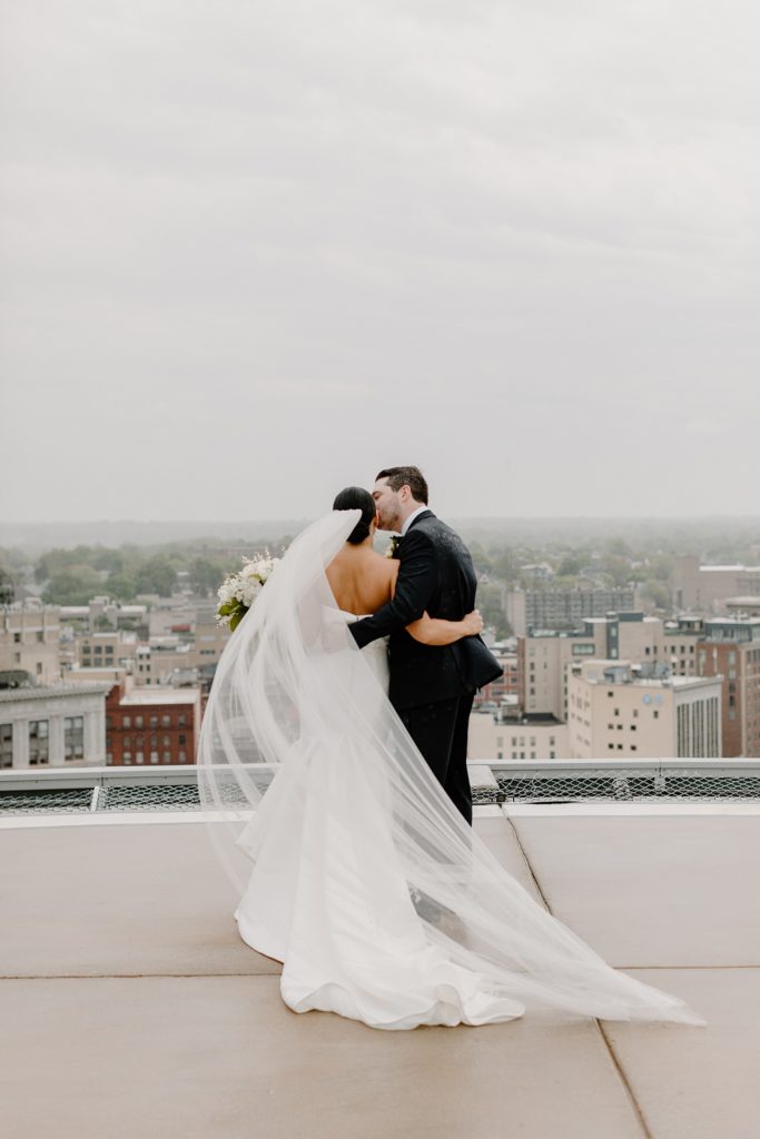 bride and groom kissing in the rain 