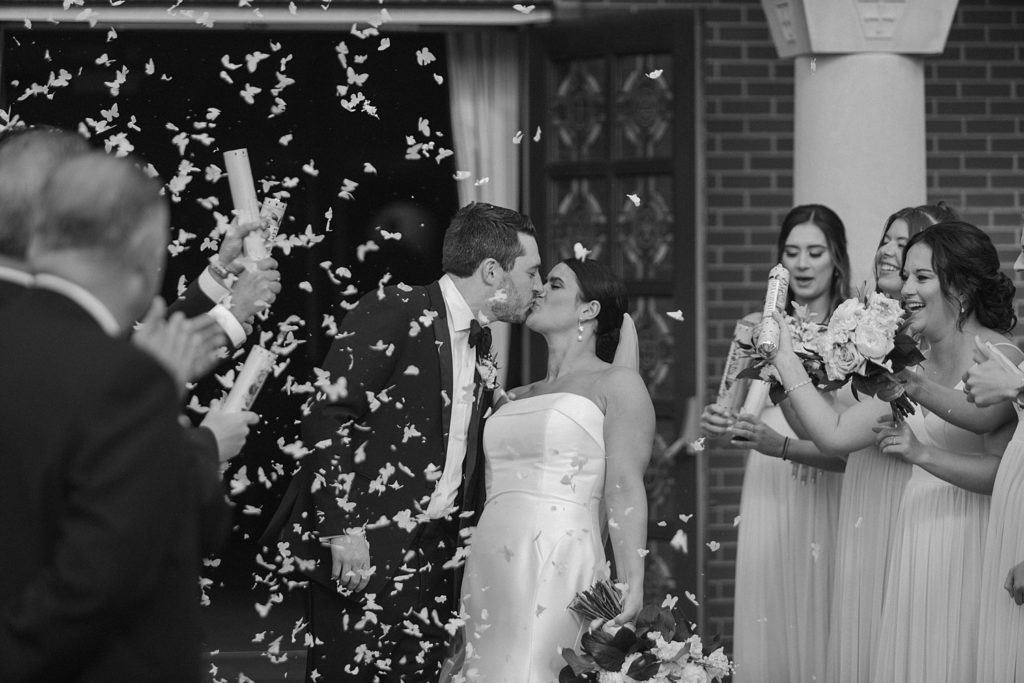 couple kissing while confetti falls 