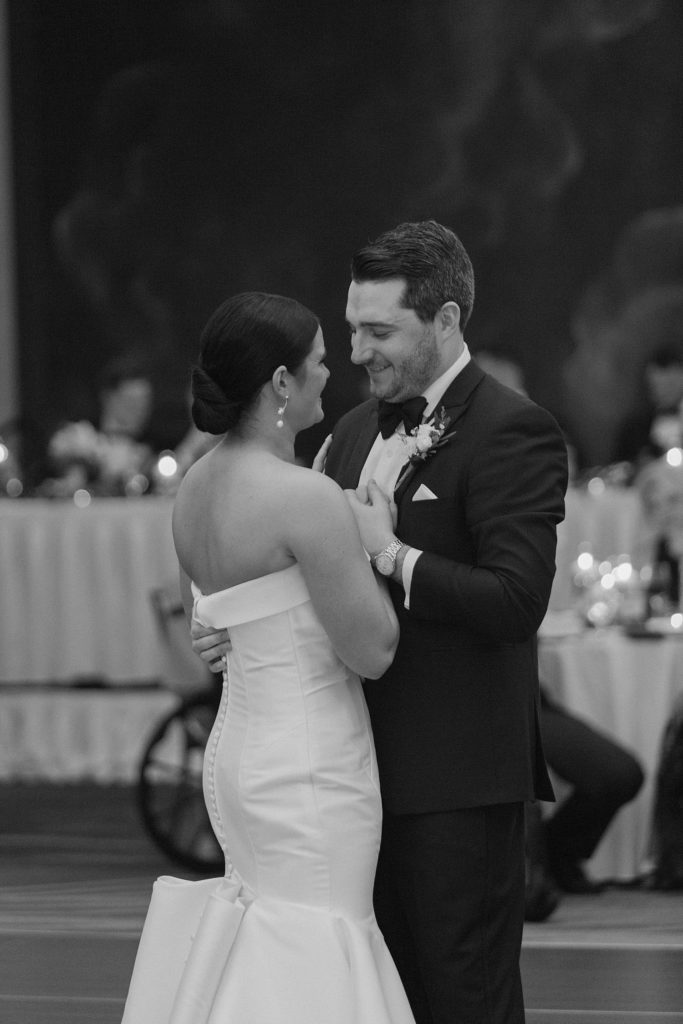 bride and groom on the dance floor smiling at each other 