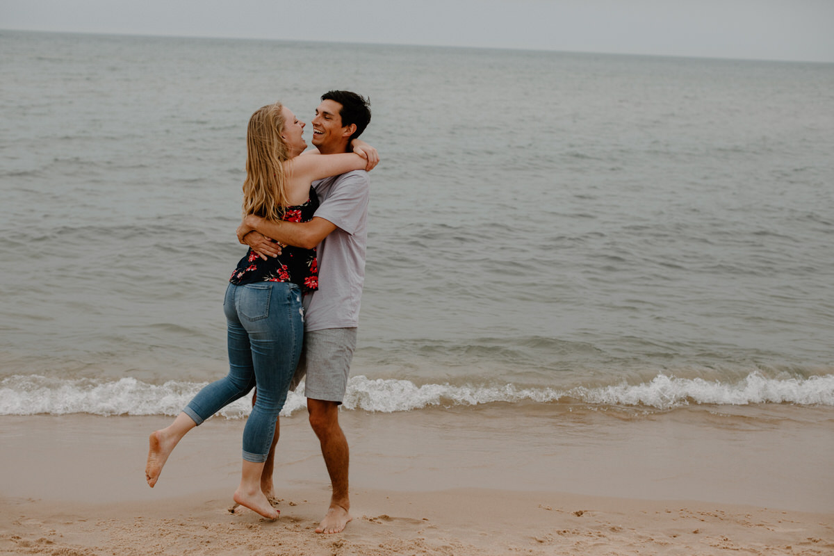 couple hugging on the edge of the water at the beach