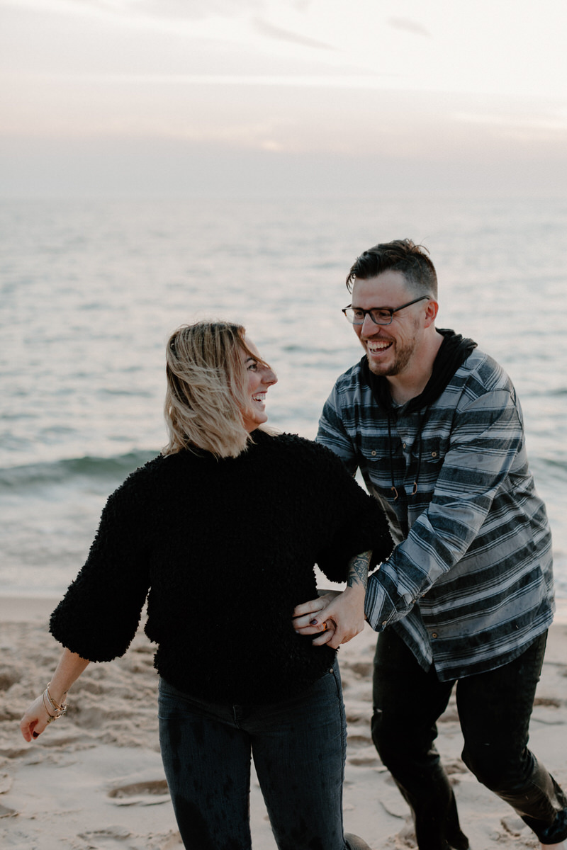 man reaching for woman from behind as they laugh together 