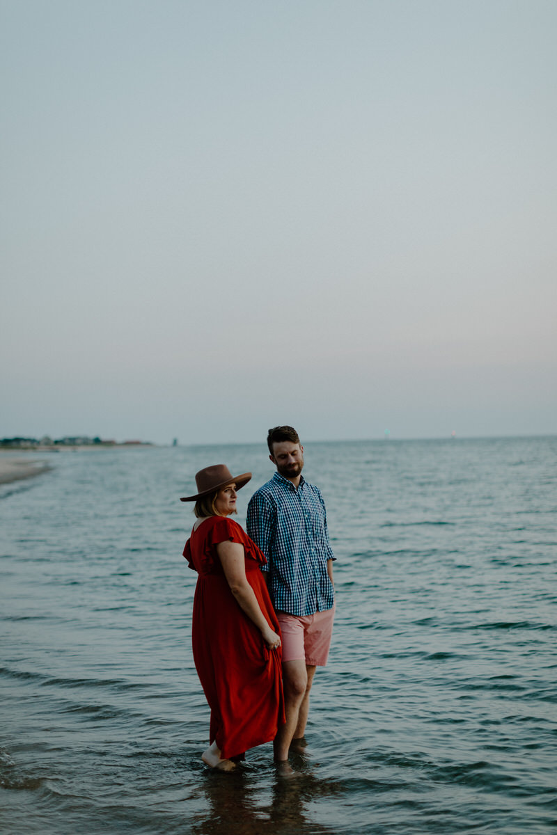 couple standing in shallow water on the beach