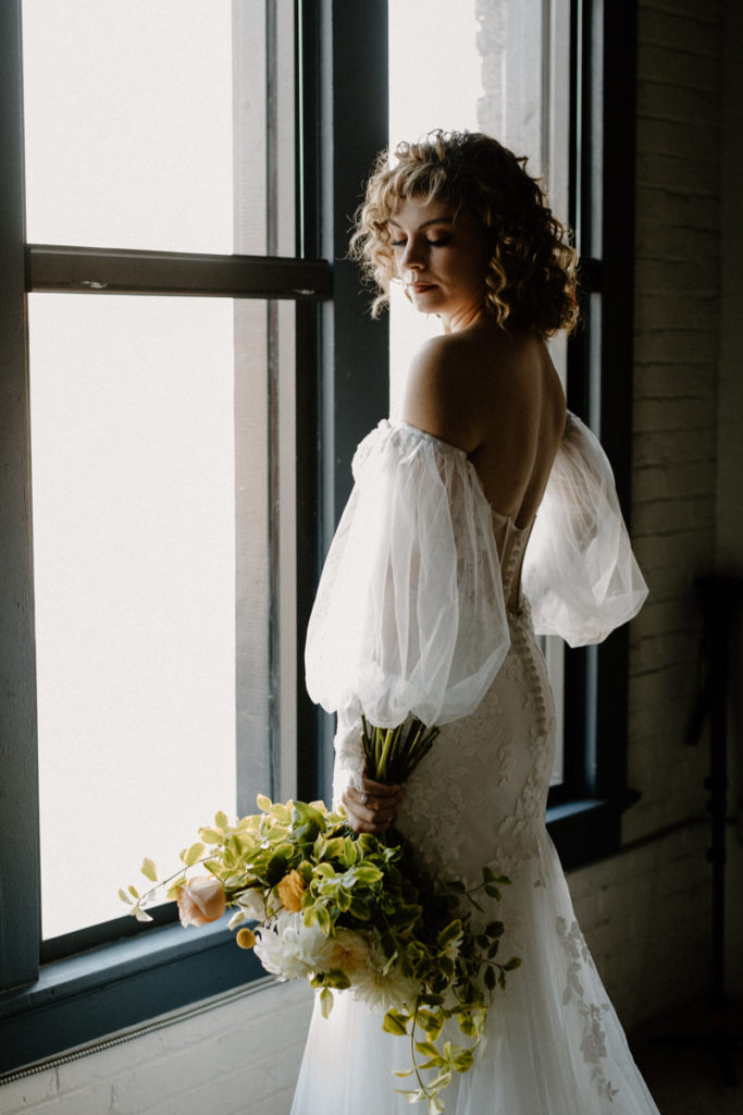 bride standing by window looking over her shoulder