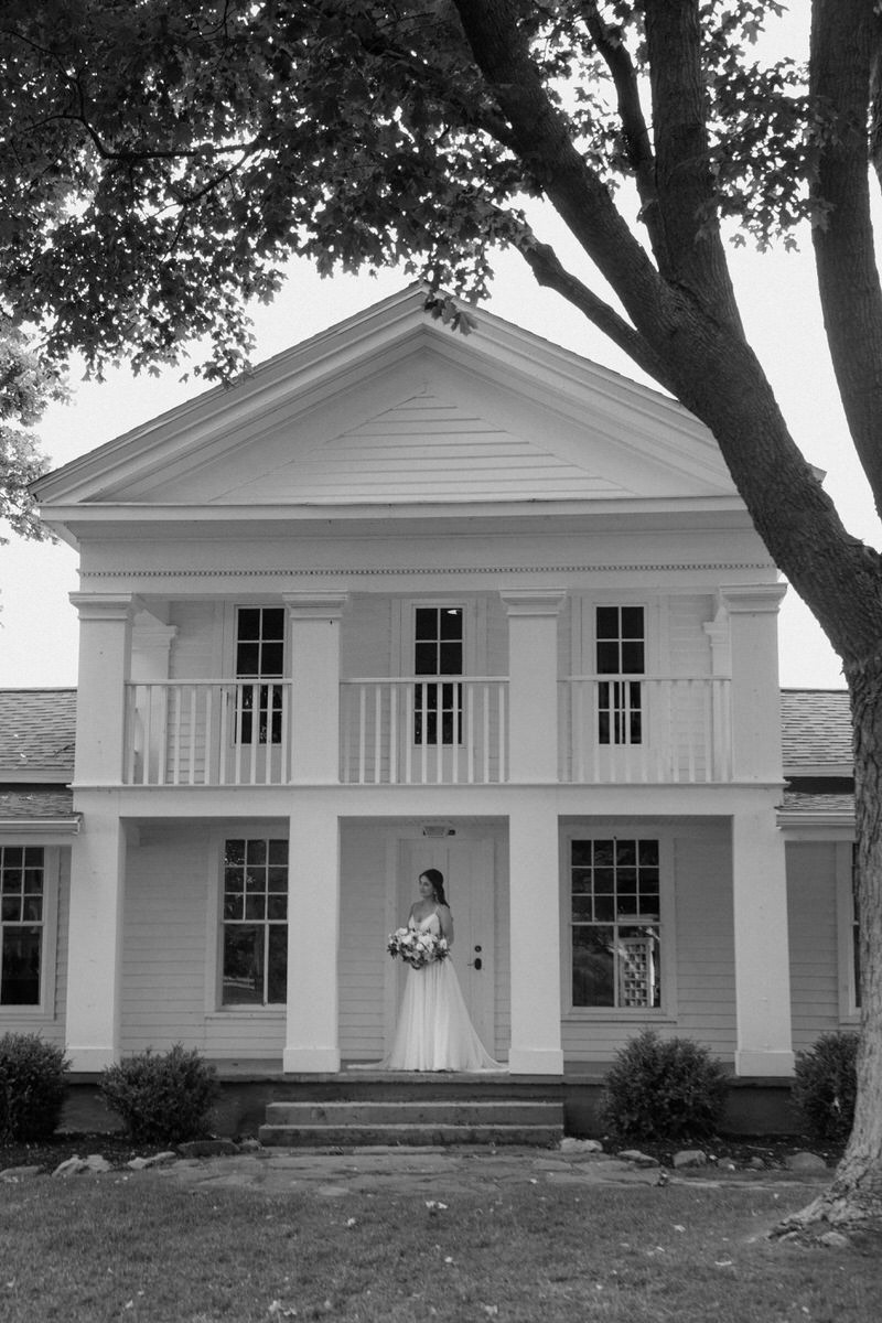 bride standing in front of large white building