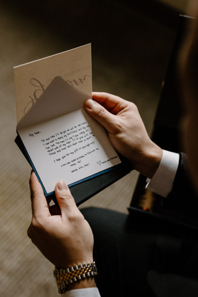 close up view of two hands holding a hand written letter 