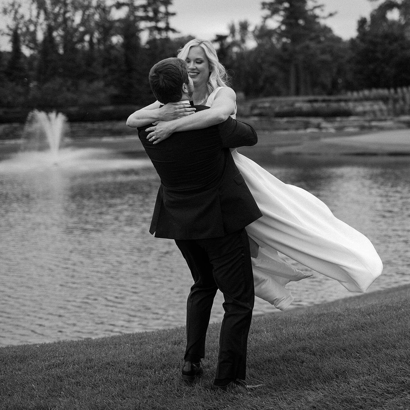 groom twirling around bride on their wedding day outside on a golf course